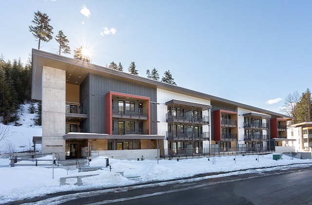 A three-storey apartment building surrounded by snow.