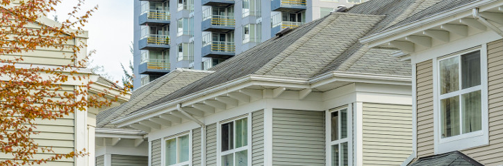 Roofs of homes in foreground with apartment complex in background