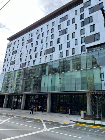 High-rise building with a modern design, featuring numerous windows of varying sizes and a glass overlay on the exterior of the second and third floors.