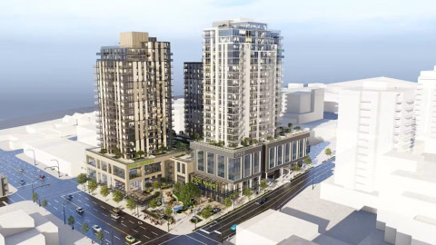 A modern urban complex with two glass high-rise buildings connected by a lower structure labelled "FOOD MARKET" and "OFFICES," located at a busy street intersection.