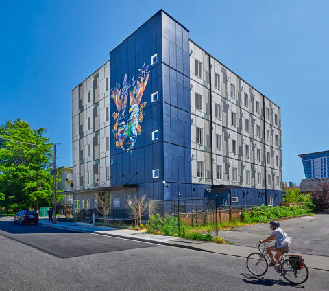 A modern multi-story building with a large, colourful mural of a butterfly on its side.