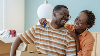 Happy couple showing key of their apartment 