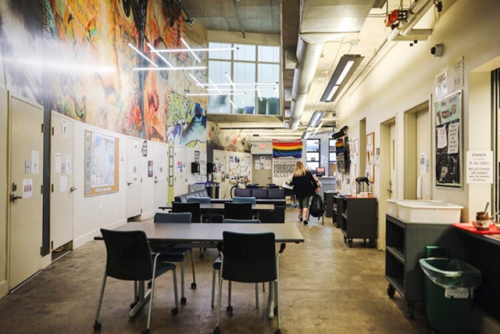 A colourful, bright multi-use space with vacant tables and chairs and artwork on the walls