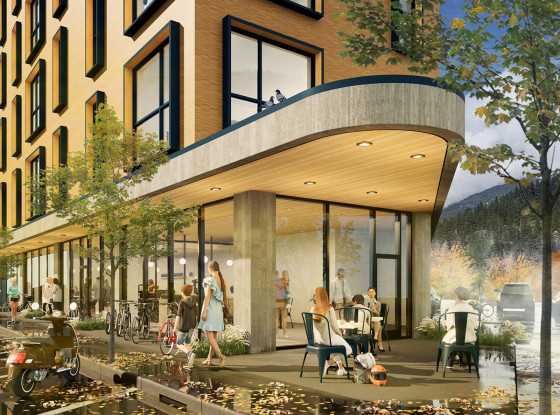 Urban street scene with a modern multi-story building featuring large windows and a concrete canopy, where people walk and sit at outdoor café tables; bicycles are parked nearby, autumn-colored trees line the street, and mountains rise in the background.