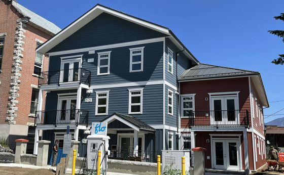 A multi storey building with blue and red siding and white trim.