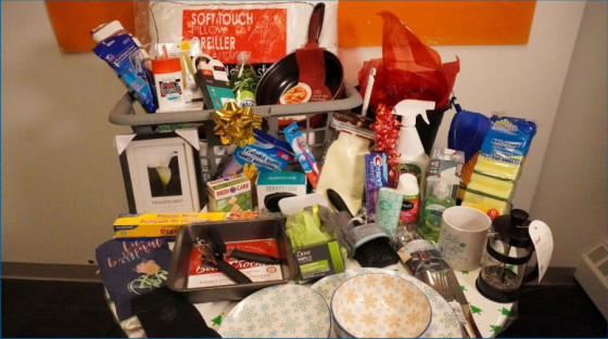 Table with assorted items including dishes, a coffee cup, a frying pan, and personal care products.