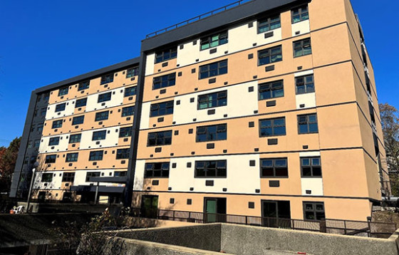 a newly updated exterior of a brown and beige 6 story building.