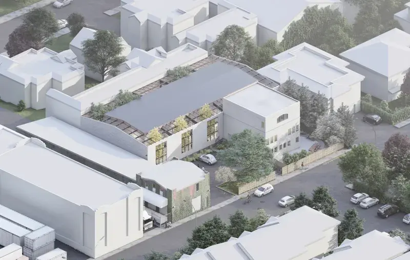 Aerial rendering of a modern building with a curved roof set among residential homes and tree‑lined streets.