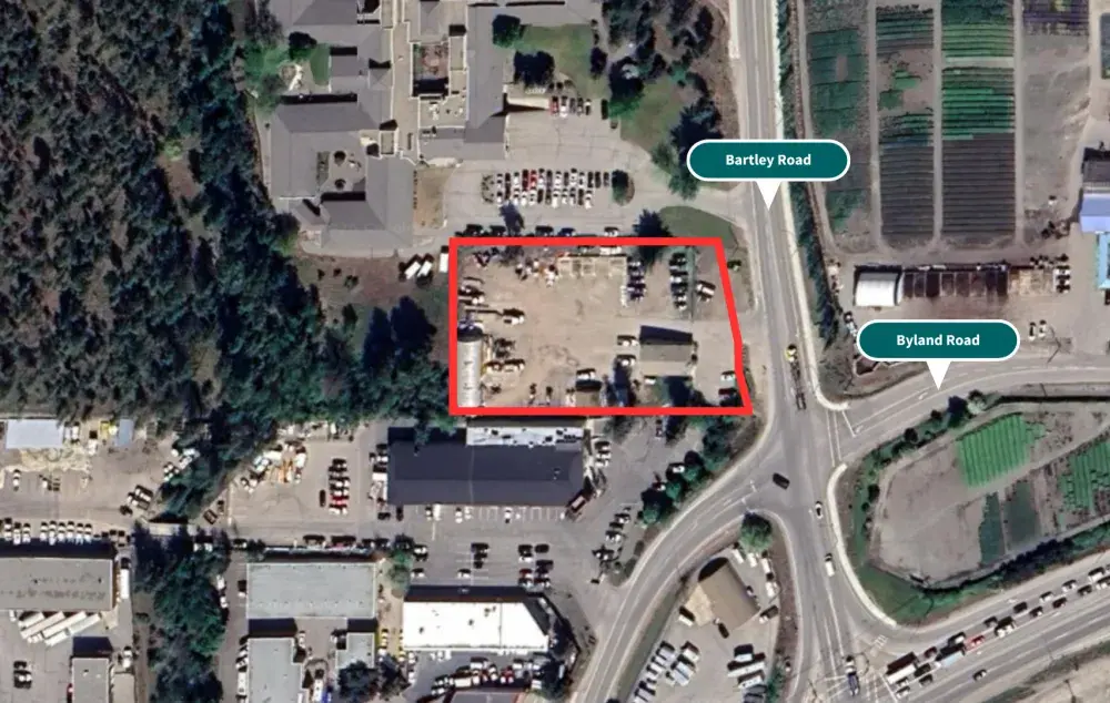 Aerial view of a commercial lot outlined in red near Bartley Road and Byland Road, surrounded by buildings, parked vehicles, and farmland.