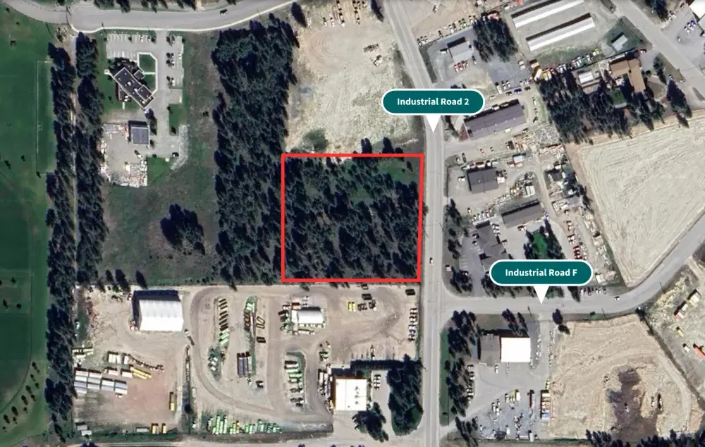 Aerial view of a tree-covered site outlined in red beside Industrial Road 2, surrounded by industrial properties.